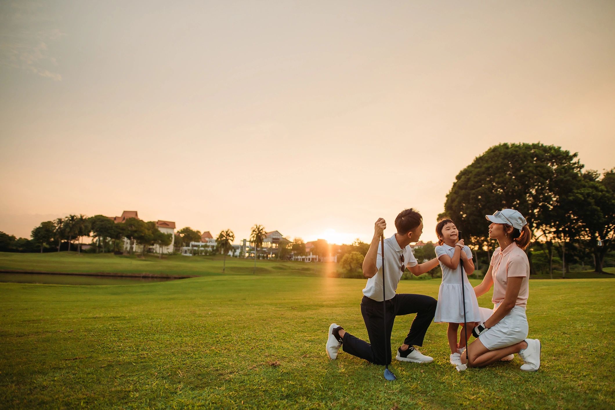 Family enjoying time together on a golf course at sunset