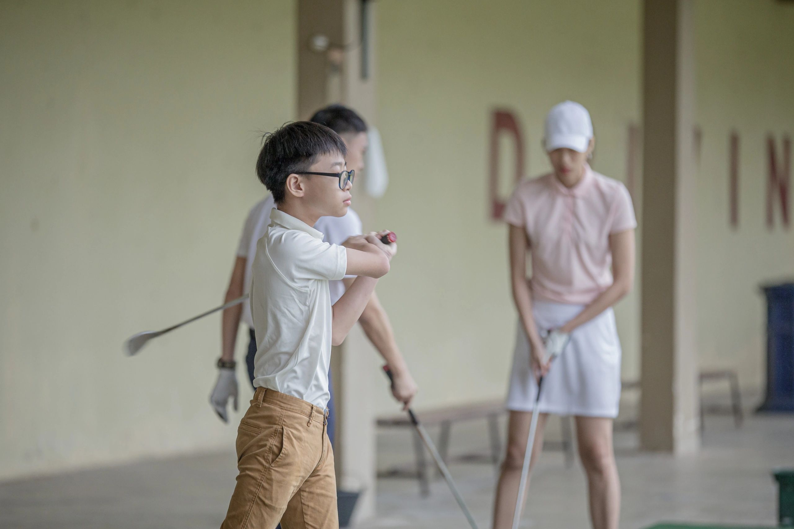 Teen golfer teeing off at a driving range
