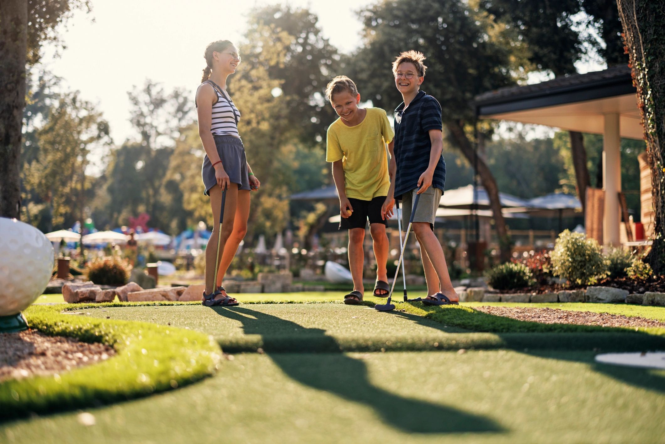 Kids playing mini golf together