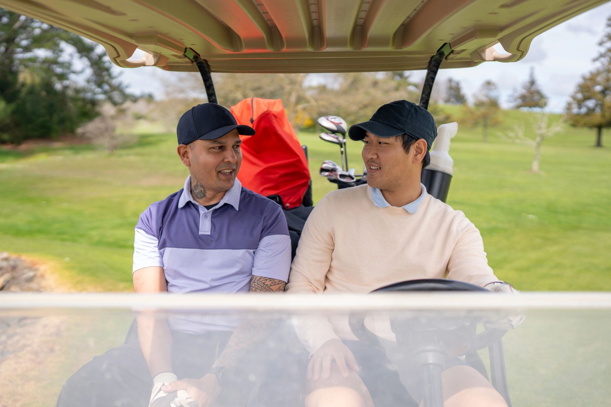 Two golfers chatting in a golf cart